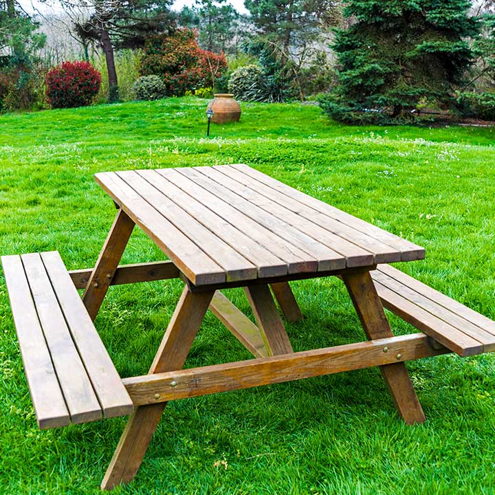 Picknicktisch mit Bänken aus Holz auf einer Rasenfläche