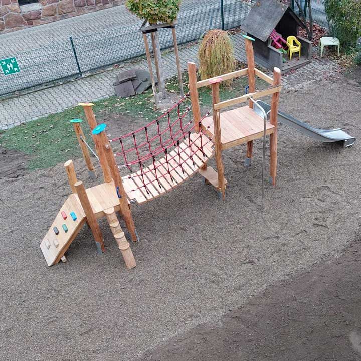 Kletteranlage aus Robinienholz mit Netz und Balken auf einem Spielplatz